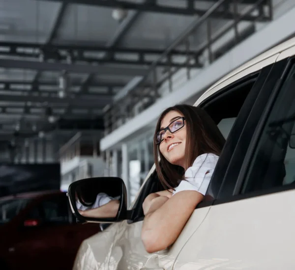 smiling-woman-inside-a-yellow-car-looking-up-2026-01-09-00-39-43-utc-1